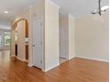 Open-concept living space with wood floors and arched doorway at 135 Cedar Elm Rd, Durham, NC 27713