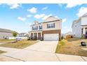 Charming two-story home with a brick and vinyl exterior, attached two-car garage, and front yard at 1427 Carisbrooke Dr, Mebane, NC 27302