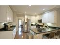 Bright kitchen with white cabinets, stainless steel appliances, and an island with seating at 1505 Sharnbrook Ct, Raleigh, NC 27614