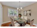 Inviting dining room featuring a glass table, stylish chandelier, and hardwood flooring at 154 Luther Rd, Raleigh, NC 27610