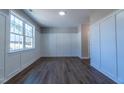 Bright living room featuring hardwood floors, wainscoting wall trim, and a large window letting in natural light at 213 Delma Grimes Rd, Coats, NC 27521