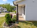Inviting covered porch with brick detail, complemented by lush landscaping and a well-manicured lawn at 220 Brisbane Dr, Zebulon, NC 27597
