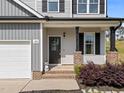View of the front door, porch, and landscaping of a well-maintained two-story home at 220 Brisbane Dr, Zebulon, NC 27597