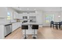 Bright, modern kitchen with stainless steel appliances, white cabinets, and a large island with seating at 220 Brisbane Dr, Zebulon, NC 27597