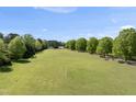 Expansive pasture with green grass surrounded by trees and wooden fences on a sunny day at 220 Jordan Narron Rd, Selma, NC 27576