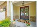 Charming front entrance featuring double doors, decorative wreaths, and well-placed potted plants at 2307 Carriage Oaks Dr, Raleigh, NC 27614