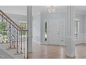 Bright and spacious foyer with hardwood floors, elegant chandelier, and staircase with wood railings at 2412 Castleburg Dr, Apex, NC 27523