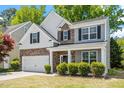 Charming two-story home with stone and siding exterior, two-car garage, and well-manicured landscaping at 3411 Massey Pond Trl, Raleigh, NC 27616
