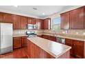 Well-lit kitchen features stainless steel appliances, an island, and brown wooden cabinets at 3513 Diamond Springs Dr, Raleigh, NC 27610