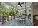 Relaxing back porch with a porch swing, ceiling fan, and an outdoor rug overlooking green trees at 398 Carolina Ave, Raleigh, NC 27606