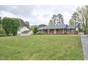 Charming brick ranch with large front yard and mature trees offering curb appeal at 4005 King Charles Rd, Durham, NC 27707