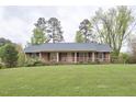 Charming brick ranch with large front yard and mature trees offering curb appeal at 4005 King Charles Rd, Durham, NC 27707
