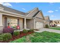 Beautiful home exterior showcasing manicured landscaping, a two-car garage, and inviting front porch at 4020 Kinsley Trce, Burlington, NC 27215