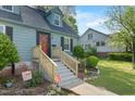 Inviting home showcasing newly renovated stairs, complemented by lush landscaping, and a home security system at 417 S Fourth St, Mebane, NC 27302