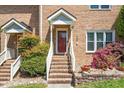 Close-up of the front door and entryway of a brick townhome, showing the steps and landscaping at 5500 Fortunes Ridge Dr # 82B, Durham, NC 27713