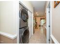 Hallway featuring an in-unit washer and dryer and tile flooring leading to the kitchen at 5500 Fortunes Ridge Dr # 82B, Durham, NC 27713