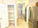 A hallway features a pantry, stainless steel refrigerator, and washer and dryer at 5500 Fortunes Ridge Dr # 82B, Durham, NC 27713
