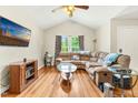 Bright living room featuring a vaulted ceiling, hardwood floors, and a comfortable sectional sofa at 5860 Andover Dr, Graham, NC 27253