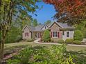 Beautiful single story stone home with mature landscaping and red shutters at 6824 Wood Forest Dr, Cary, NC 27519