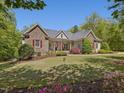 Lovely home featuring stone accents, a pristine lawn, and attractive curb appeal at 6824 Wood Forest Dr, Cary, NC 27519