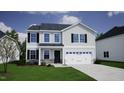 Exterior elevation of a two-story home with stone accents, a two-car garage, and a well-manicured lawn at 75 Cordoba Dr, Franklinton, NC 27525
