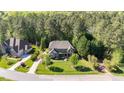 A beautiful home nestled among lush trees, showcasing its well-manicured lawn and serene setting at 7633 Summer Pines Way, Wake Forest, NC 27587