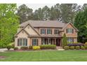Charming two-story home with stone and shingle facade, complemented by lush landscaping and a cozy front porch at 7633 Summer Pines Way, Wake Forest, NC 27587