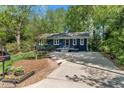 Inviting blue house with a well-maintained lawn and a spacious driveway at 7653 Summerglen Dr, Raleigh, NC 27615