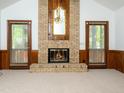 Cozy living room with a brick fireplace, complemented by glass doors and wood paneling at 7716 Bluff Top Court Ct, Raleigh, NC 27615