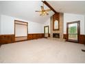 Spacious living room featuring a brick fireplace, beamed ceiling, and wood-paneled accent wall at 7716 Bluff Top Court Ct, Raleigh, NC 27615