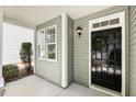 Close-up of the front porch with black door, white trim, and a stylish exterior light at 7728 Cape Charles Dr, Raleigh, NC 27617