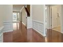 Inviting hallway with decorative wainscoting and hardwood floors leading to the living areas at 792 Eldridge Loop, Cary, NC 27519