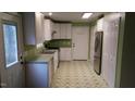 Bright kitchen with white cabinets, stainless steel appliances, and a green and white geometric floor at 82 Whisper Ln, Pittsboro, NC 27312