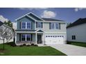 Two-story home with light gray siding, blue accent siding, and stone accents on the facade with green grass at 90 Cordoba Dr, Franklinton, NC 27525