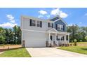 Charming two-story home with gray siding, blue accents, covered porch, and well-manicured lawn at 90 Cordoba Dr, Franklinton, NC 27525