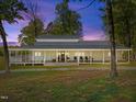 Beautiful house exterior featuring a long wraparound porch, black rocking chairs, and well-maintained landscaping at 9400 Wheelers Church E Rd, Hurdle Mills, NC 27541