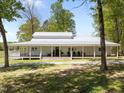 Daytime exterior view showing a house with a wraparound porch, well-maintained landscaping, and rocking chairs at 9400 Wheelers Church E Rd, Hurdle Mills, NC 27541