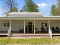 Inviting front porch with rocking chairs, wood flooring, tasteful decor, and a well-manicured lawn at 9400 Wheelers Church E Rd, Hurdle Mills, NC 27541