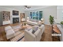Bright, staged living room featuring a fireplace, large windows, and modern furnishings at 103 Loch Ryan Way, Cary, NC 27513