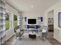 Bright and airy living room featuring plush seating, a modern desk, and a large window overlooking the landscape at 1113 Landen Creek Ln, Zebulon, NC 27597