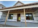 View of the unfinished porch with exposed support beams and black framed windows at 11226 Old Beulah Rd, Kenly, NC 27542