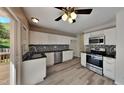 Well-lit kitchen with stainless steel appliances, white cabinets, mosaic tile backsplash, and sliding door leading to deck at 113 Union Mills Way, Cary, NC 27519