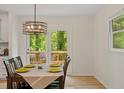 Dining area with table and chairs, light fixture, and view of the deck through glass doors at 1209 Shincliffe Ct, Cary, NC 27511