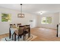 Bright dining area with wood floors, a stylish light fixture, and large windows at 1209 Shincliffe Ct, Cary, NC 27511