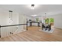 Open-concept kitchen and dining area with white cabinets, stainless steel appliances, and modern lighting at 1209 Shincliffe Ct, Cary, NC 27511