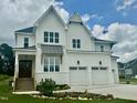 Stunning new construction home showcasing white siding, a two-car garage, and professionally landscaped front yard at 1217 Azalea Garden Cir, Raleigh, NC 27603