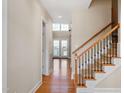 Bright foyer featuring hardwood floors, staircase with wooden railing and open view to living area at 134 Barclay Valley Dr, Cary, NC 27519