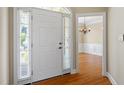 Open entryway with sidelight windows and hardwood flooring, with view of dining room with chandelier at 134 Barclay Valley Dr, Cary, NC 27519