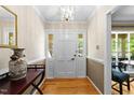 Entryway boasts hardwood floors and white trim, complemented by a stylish light fixture and front door with glass panes at 1616 Beechwood Dr, Raleigh, NC 27609