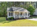 Single-story home featuring a welcoming front porch with comfortable seating and manicured lawn at 2112 Ballston Pl, Knightdale, NC 27545